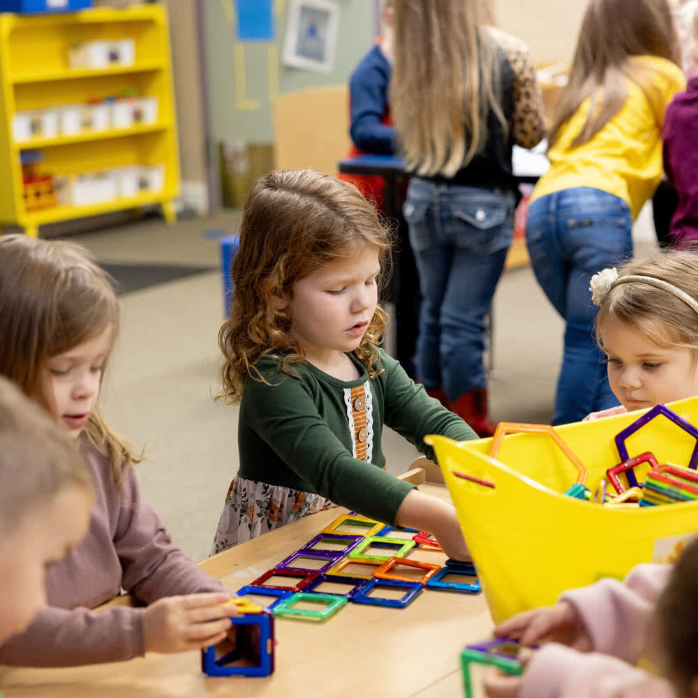 Girls playing with magnetic tiles