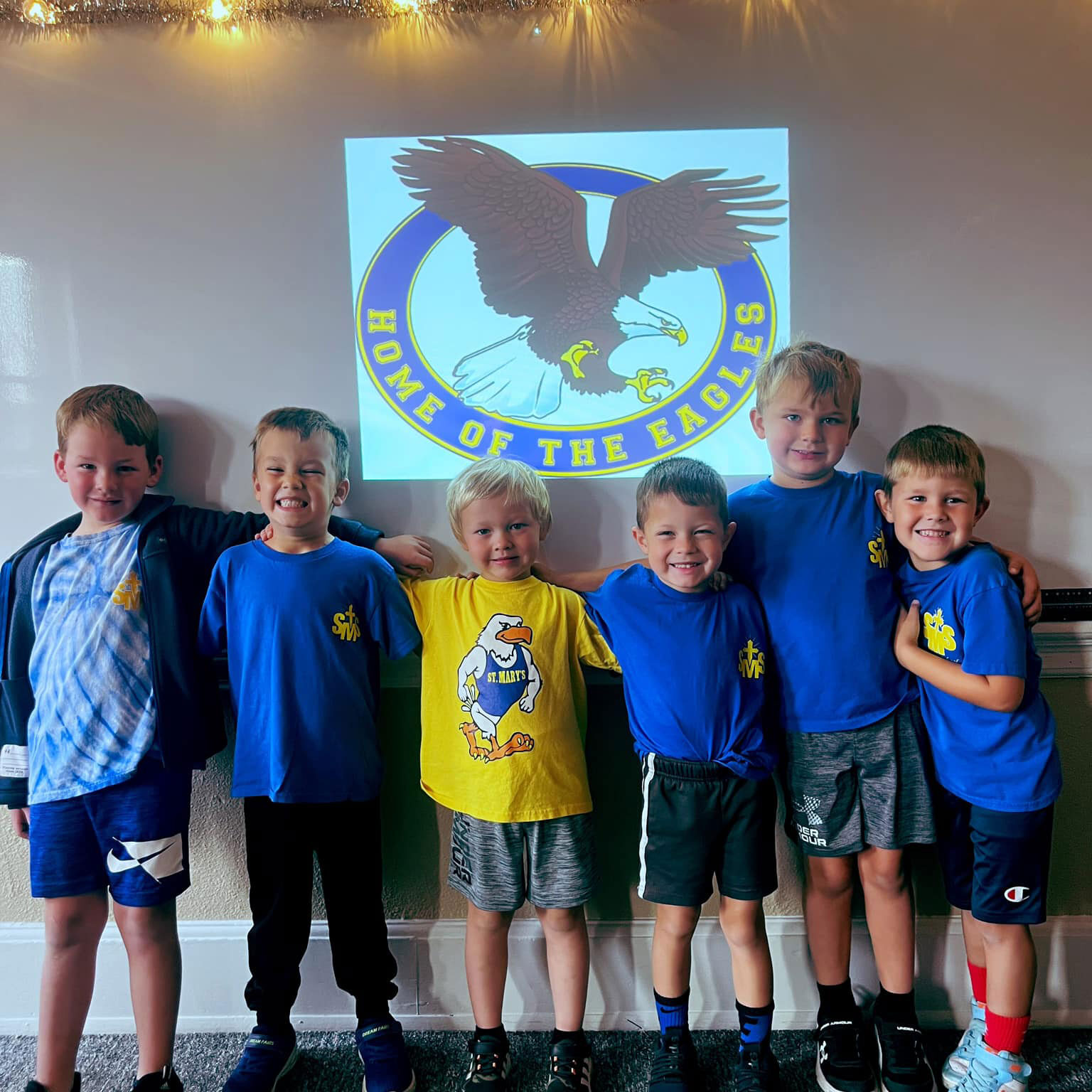 Boys in front of school projects with Home of the Eagles sign